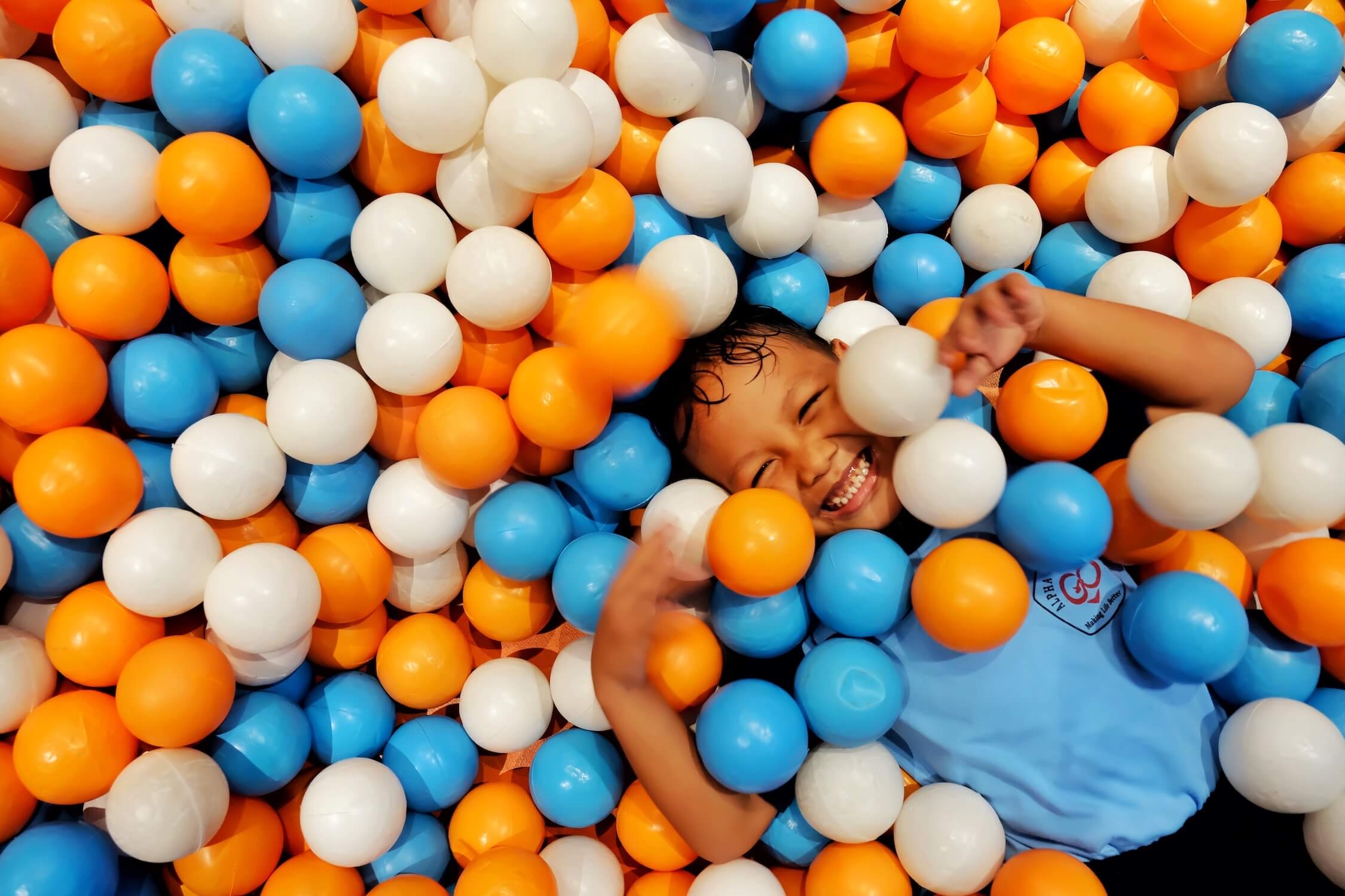 Student laughing in a ball pit
